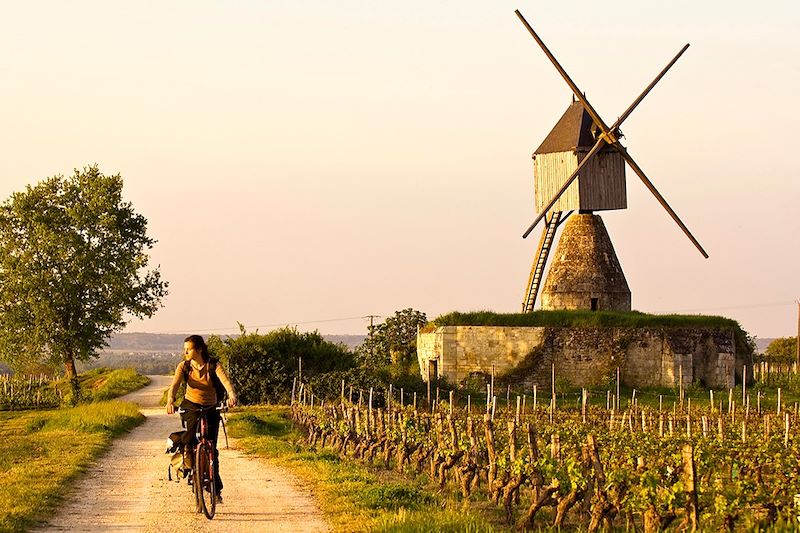 Cycliste passant devant un moulin près de Montsoreau - France
