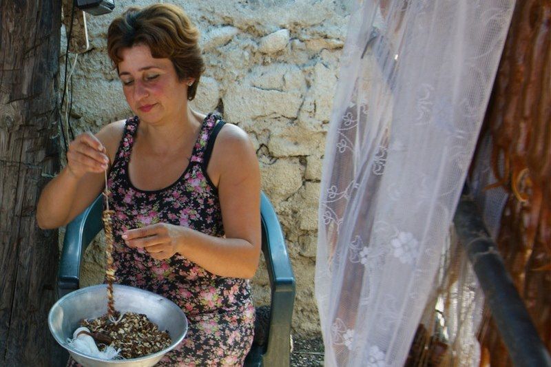 Femme géorgienne préparant des Churchkhela
