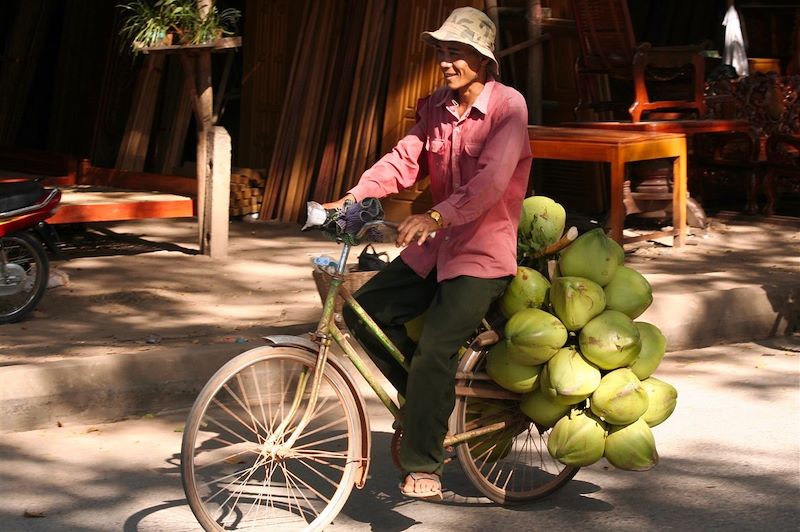 Homme transportant des noix de coco - Cambodge