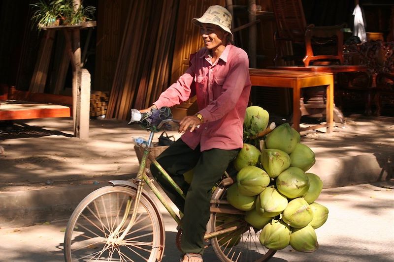 Homme transportant des noix de coco - Cambodge