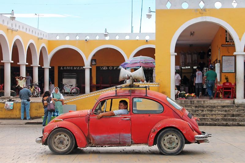 Homme dans une voiture devant un marché - Izamal - Mexique