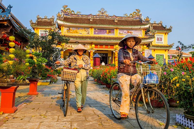 Cyclistes devant la pagode Phap Bao - Hoi An - Vietnam