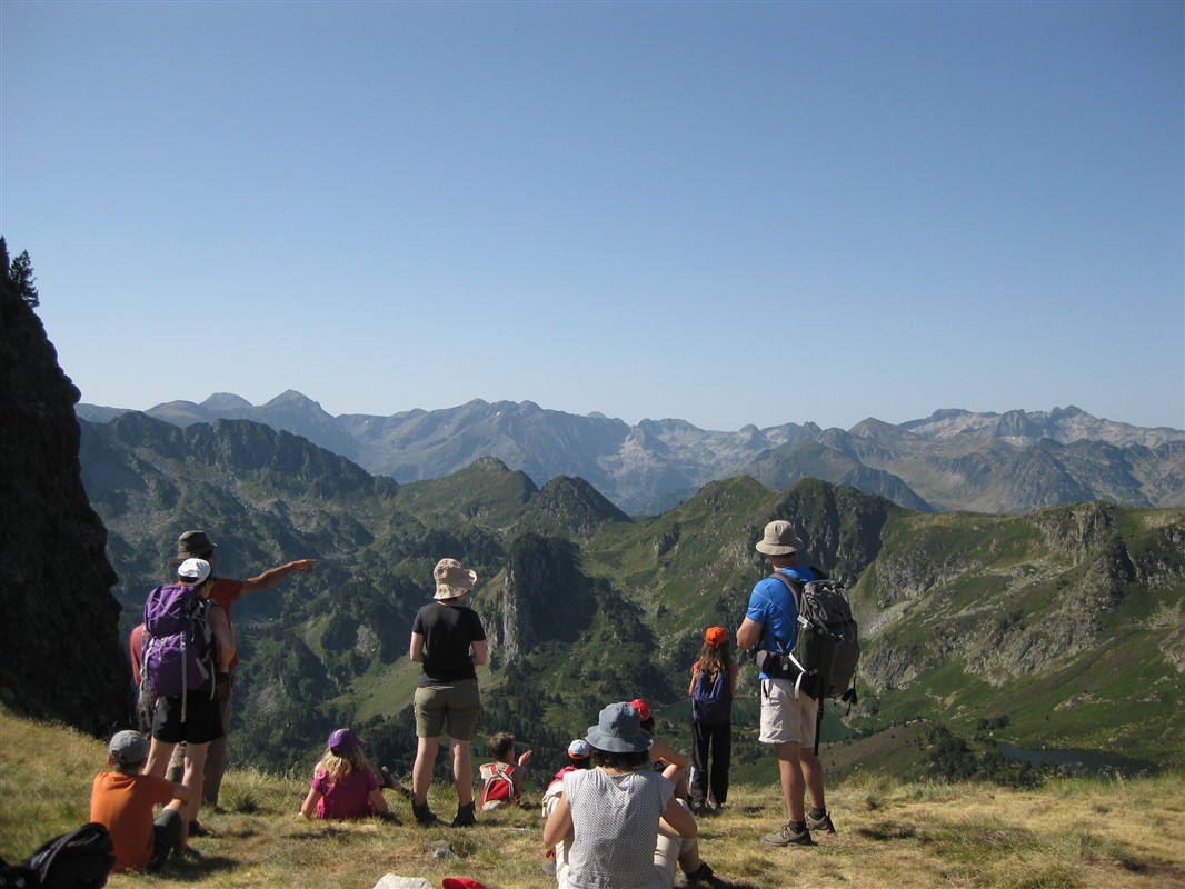 Randonnée en famille près d'Ax-les-Thermes dans les Pyrénées © Guillaume Jollibert Groupe de familles face aux paysages de montagne dans les Pyrénées