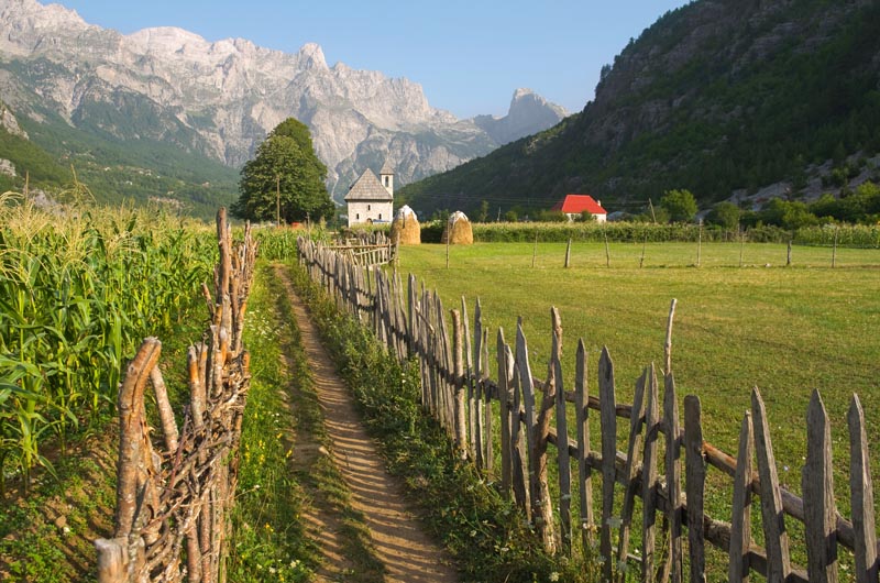 Sentier entre les cultures et vue sur les Alpes dinariques - Parc national de Thethi - Albanie