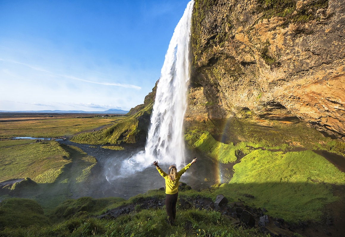 Femme devant la cascade de Seljalandsfoss dans la région de Suðurland 