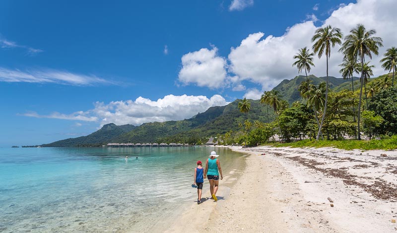 Enfant avec sa m&egrave;re marchant sur une plage en Polyn&eacute;sie &copy; AlexQ/stock.adobe.com