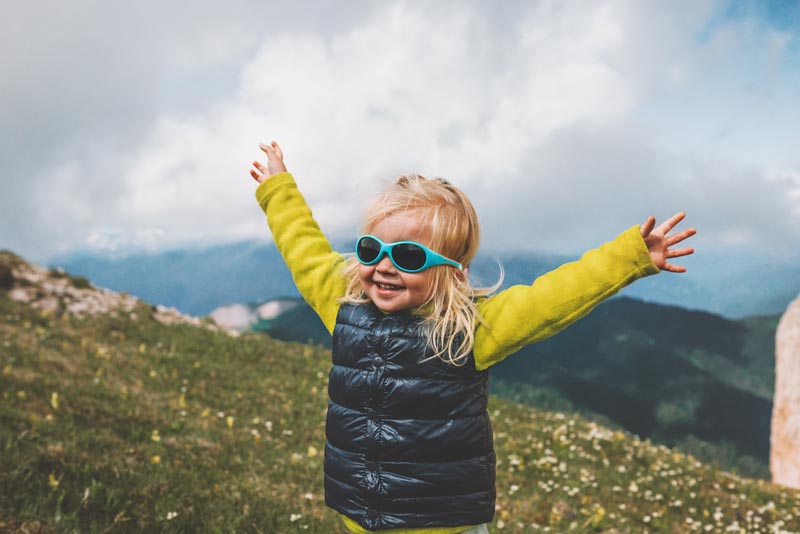 Port de lunettes de soleil à la montagne par une jeune enfant © EVERST/stock.adobe.com Petite fille d'environ 2 ans portant des lunettes de soleil bleues à la montagne