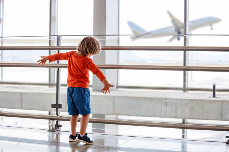 Enfant regardant un avion d&eacute;coller dans un a&eacute;roport &copy; Sergey Novikov/stock.adobe.com 