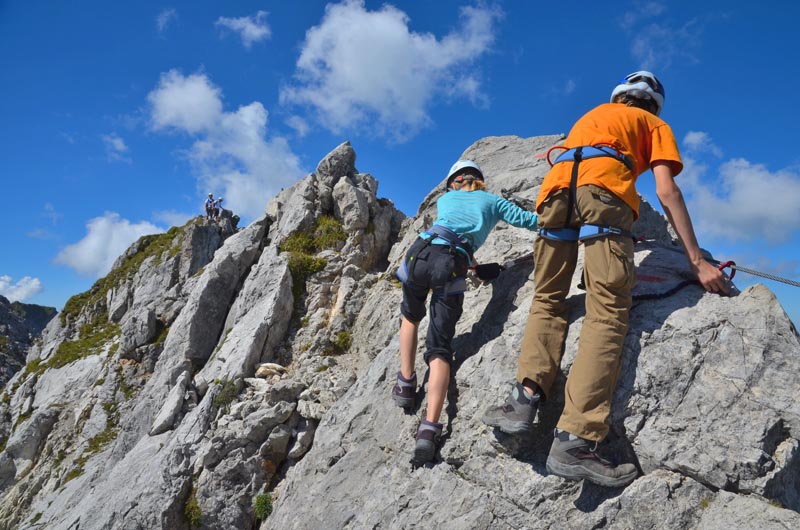 Via ferrata en famille à la montagne © Andreas P/stock.adobe.com Une fille et son père faisant de la via ferrata en montagne