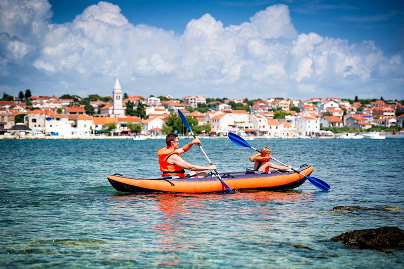 Un p&egrave;re et son fils &agrave; bord d'un kayak dans la mer - Croatie &copy; pershing/stock.adobe.com