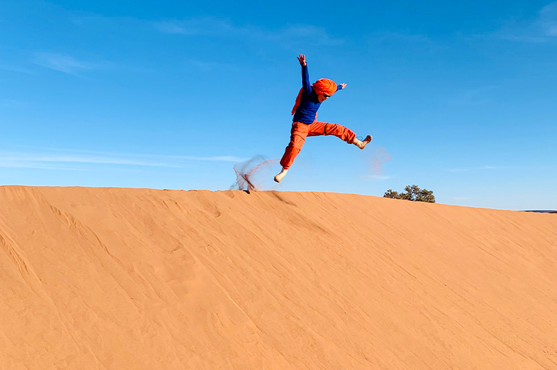 Enfant dans les dunes dans le Sahara marocain © Candice Manse/Nomade Aventure Enfant sautant dans les dunes dans le Sahara au Maroc