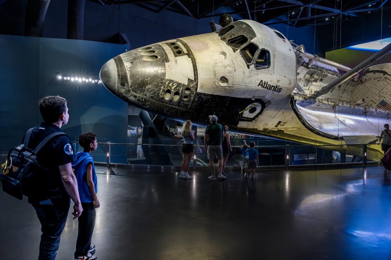 Visite en famille du Kennedy Space Center en Floride © Bertrand Rieger Un père et son fils devant la navette spatiale Atlantis exposée au Kennedy Space Center en Floride