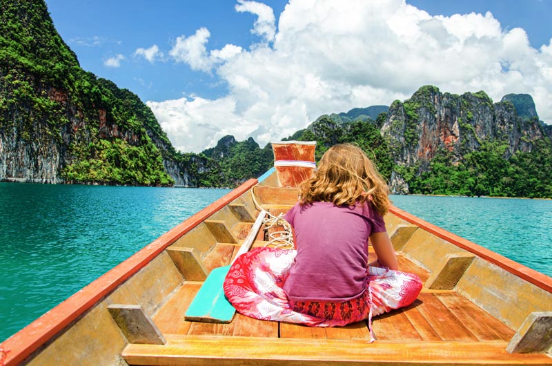 Petite fille en balade en bateau sur le lac Ratchaprapa &agrave; Khao Sok - Tha&iuml;lande &copy; Image'in/stockadobe.com 