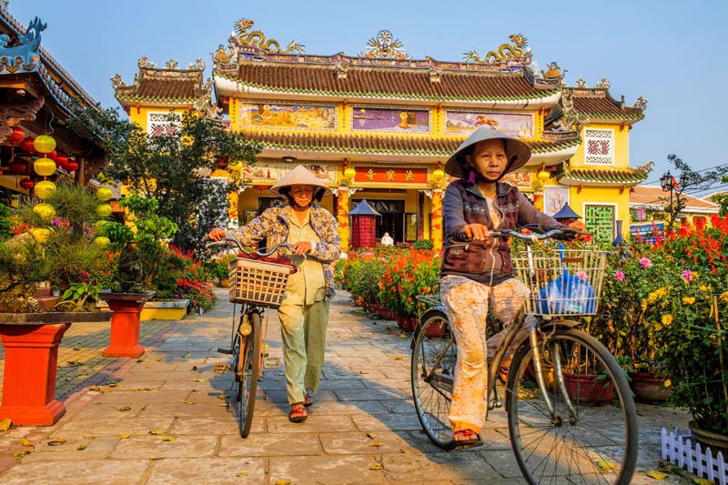 Cyclistes devant la pagode Phap Bao &agrave; Hoi An au Vietnam &copy; Franck Guiziou/hemis.fr 