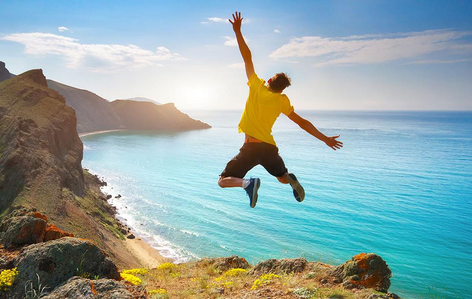 Saut de joie face à la mer et aux falaises aux États-Unis © GIS/stock.adobe.com